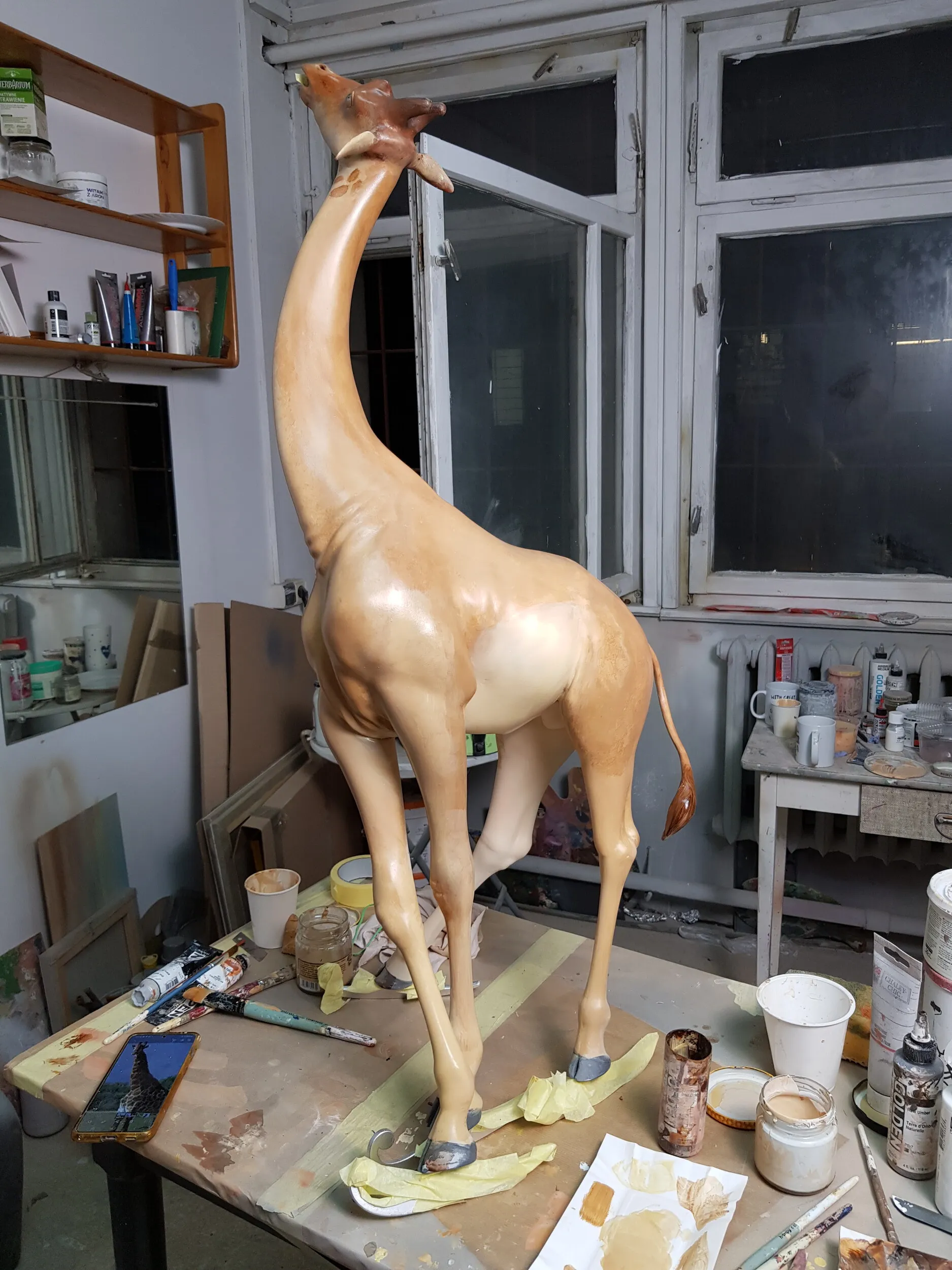 Painted skating giraffe with visible brushwork.