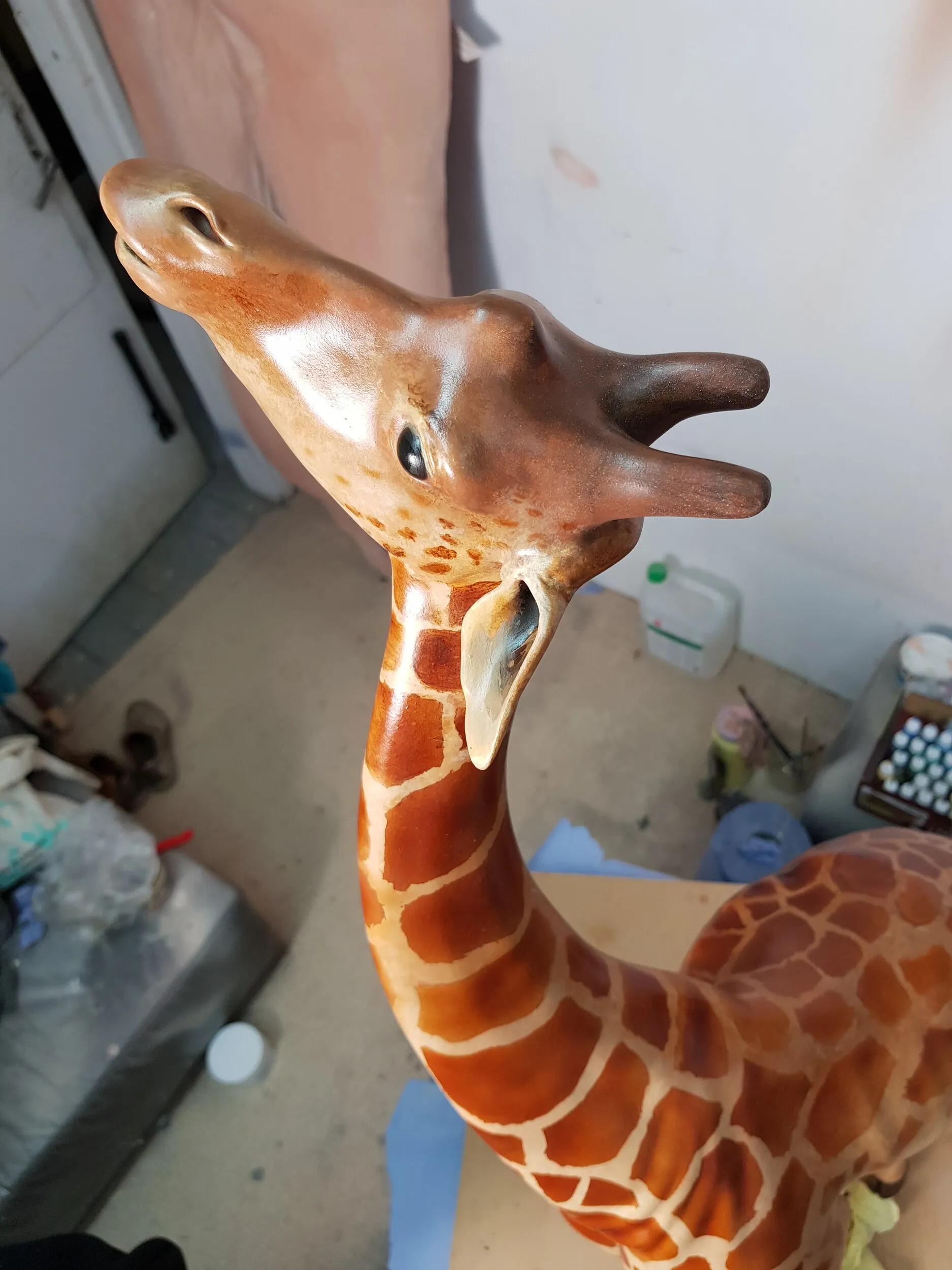 Artistic painting of patches on the giraffe figure.